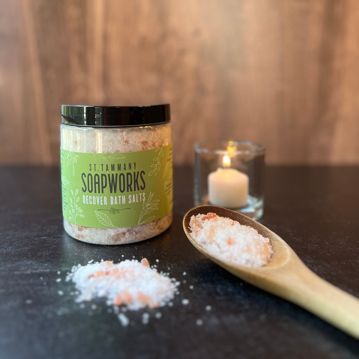 RECOVER Bath Salts jar with a candle and a scoop of salts