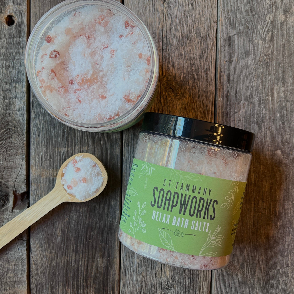Open jar of RELAX Bath Salts with a wooden scoop of pink and white salts