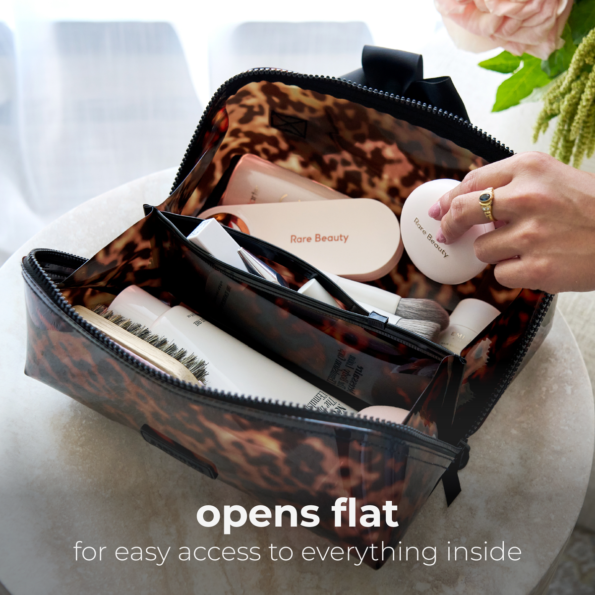 Tortoiseshell makeup bag unzipped and lying flat with makeup inside