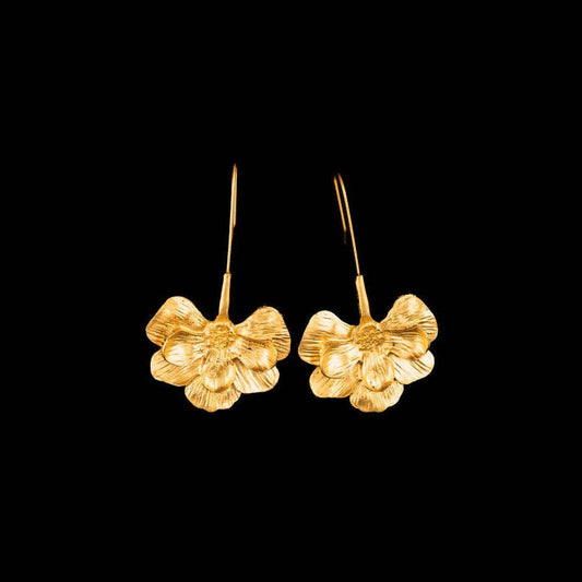 Gold floral earrings on a black background