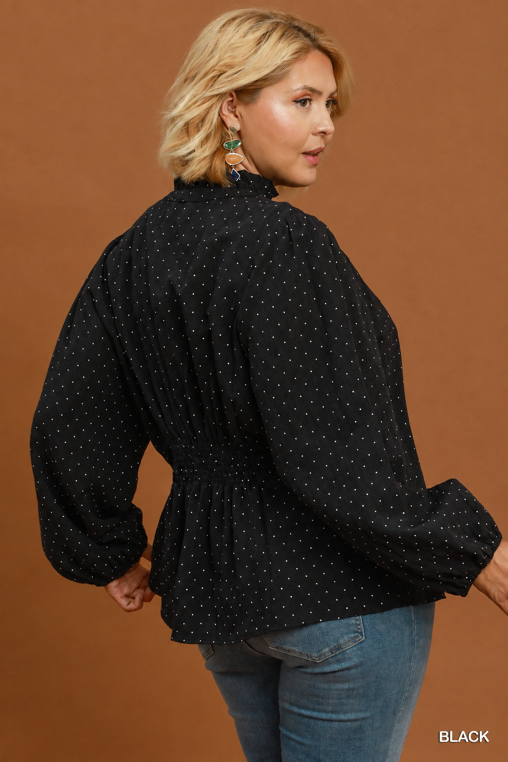 Back view of model wearing a black Swiss dot ruffle collar top with jeans