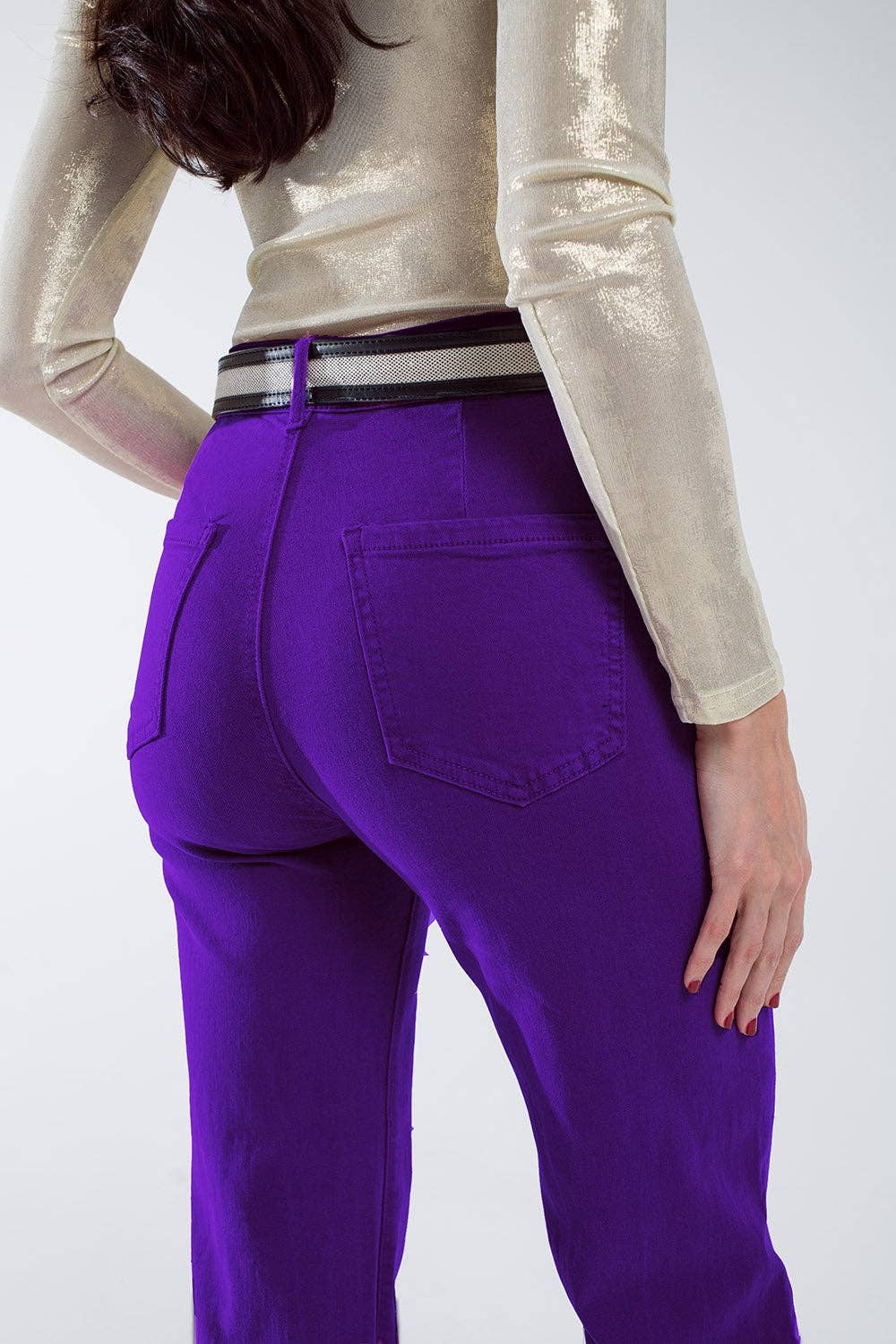 Person wearing purple jeans with a plain background