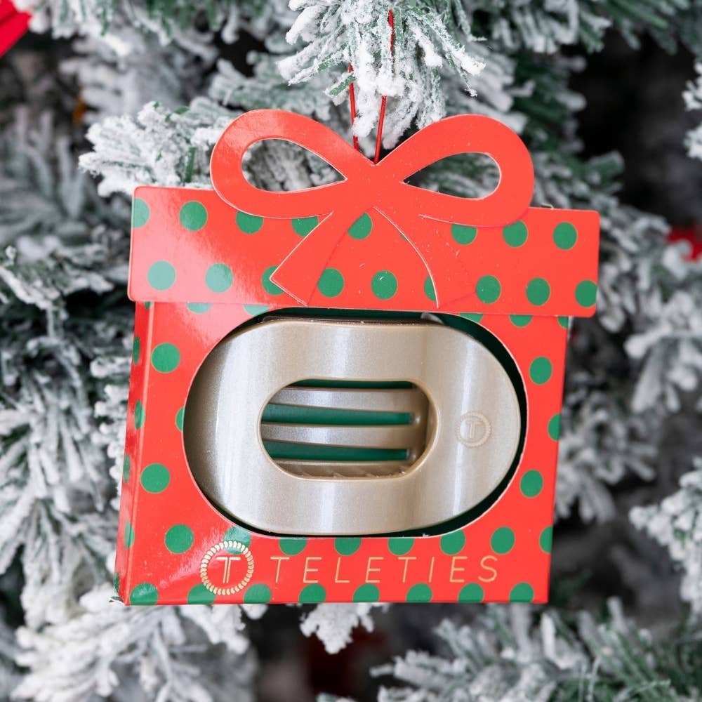 Holiday flat round hair clip ornament hanging on a Christmas tree