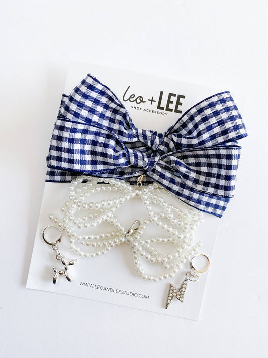 Blue and white checkered bow with pearl necklace on a white background