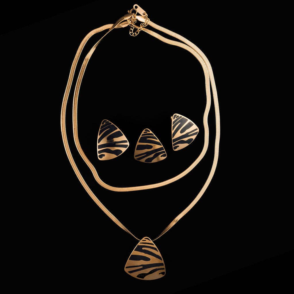 Gold-tone necklace and matching stud earrings set with teardrop-shaped zebra-stripe patterned pendants, displayed on a solid black background.