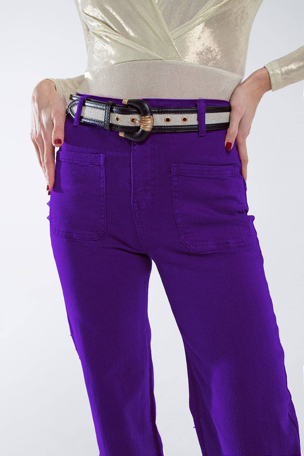Purple jeans with a belt worn by a person on a white background