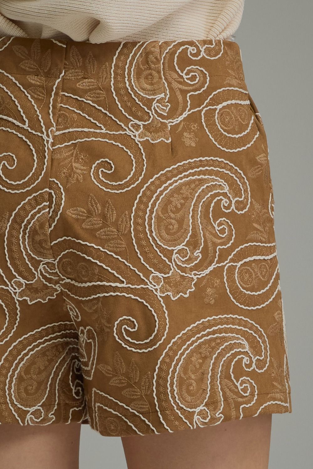 Close-up of embroidered paisley pattern on camel skort