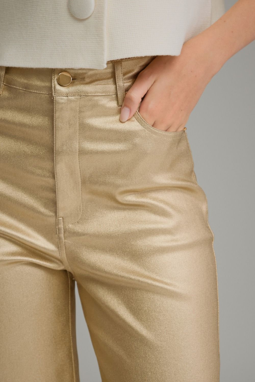 Close-up of gold metallic pants front pocket and belt loops