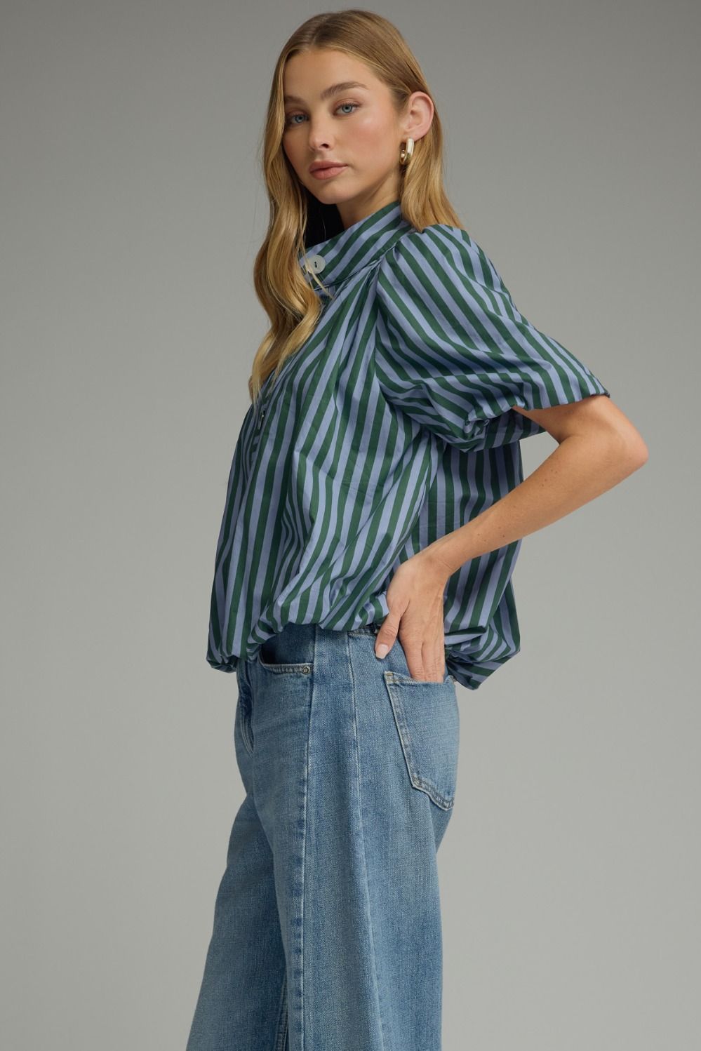 Side view of hunter green and blue stripe puff sleeve top