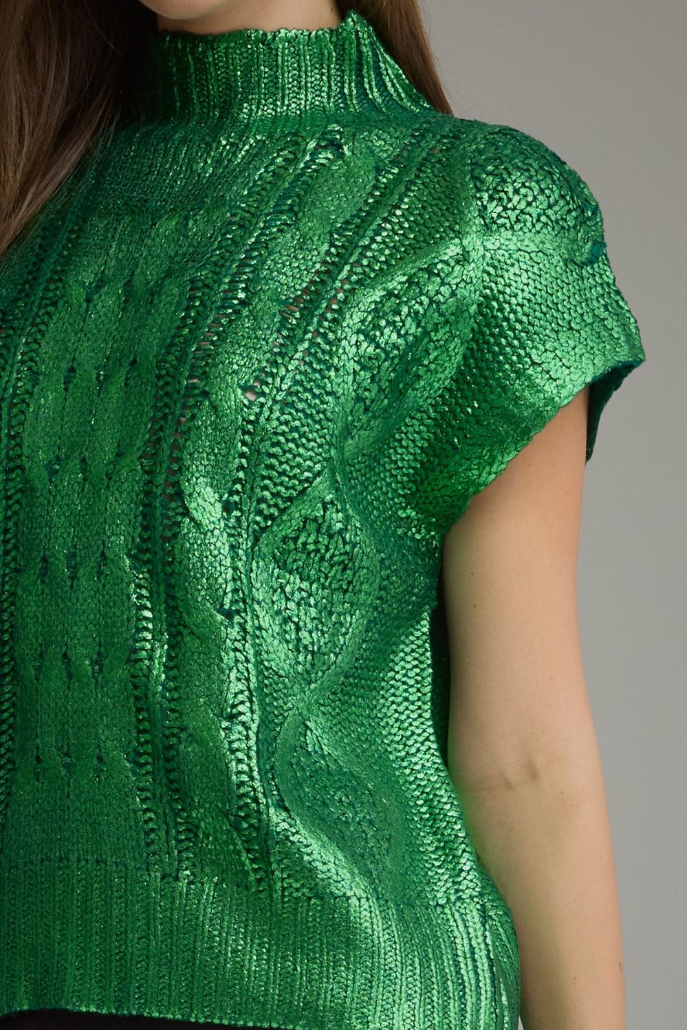 Close-up of metallic green cable knit texture and mock neck
