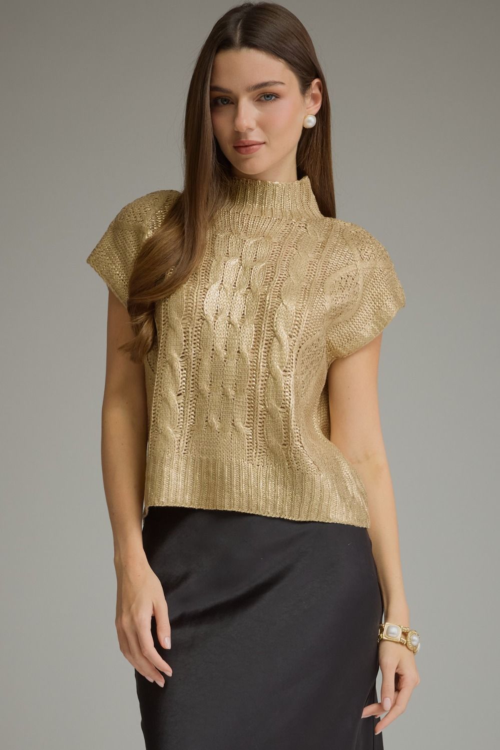 Woman wearing metallic gold cable knit mock neck sweater top, front view