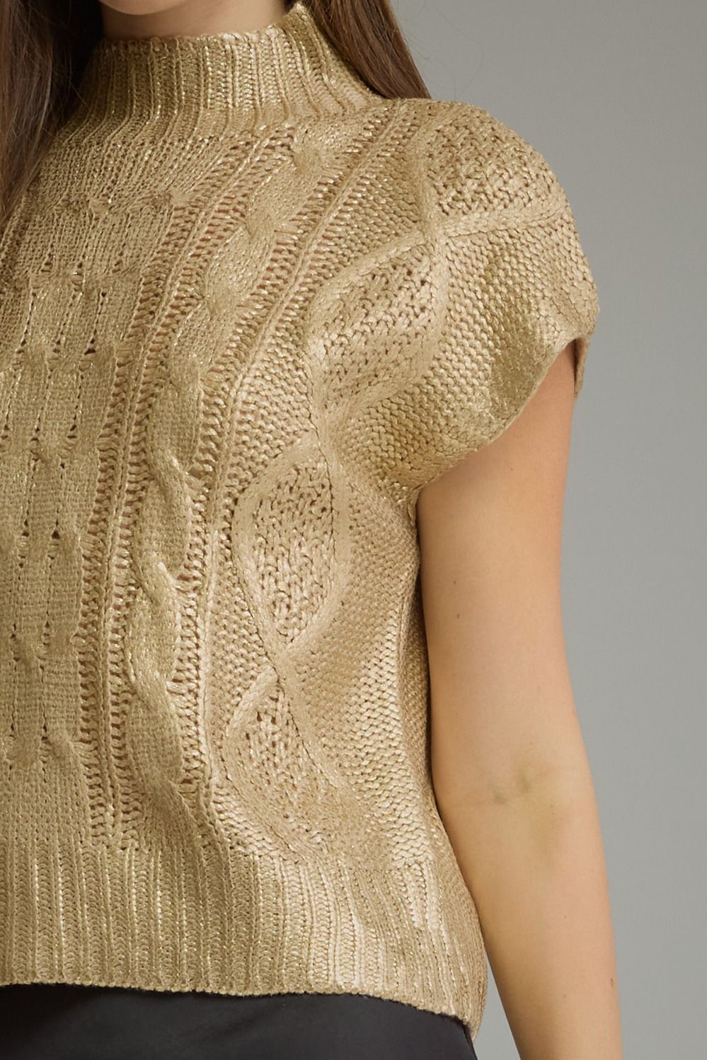 Close-up of metallic gold cable knit texture and mock neck