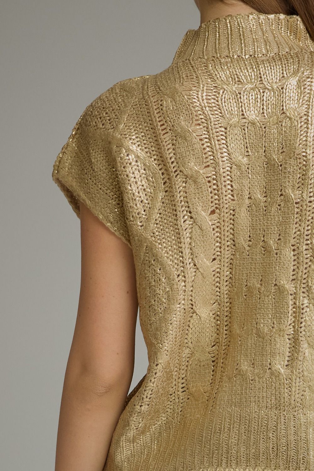Close-up back detail of metallic gold cable knit sweater top