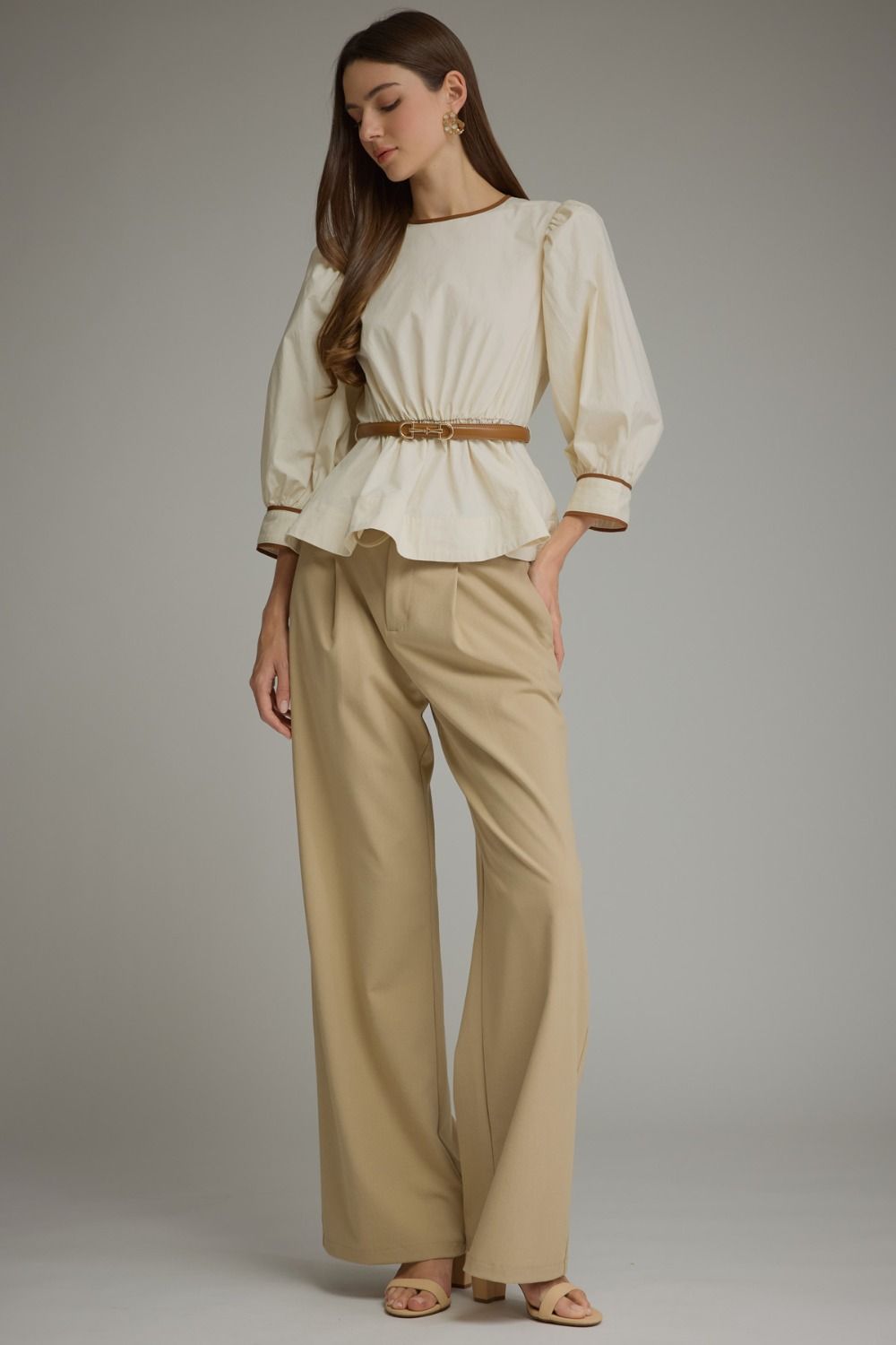 Full-length view of ecru belted puff sleeve top styled with wide-leg pants
