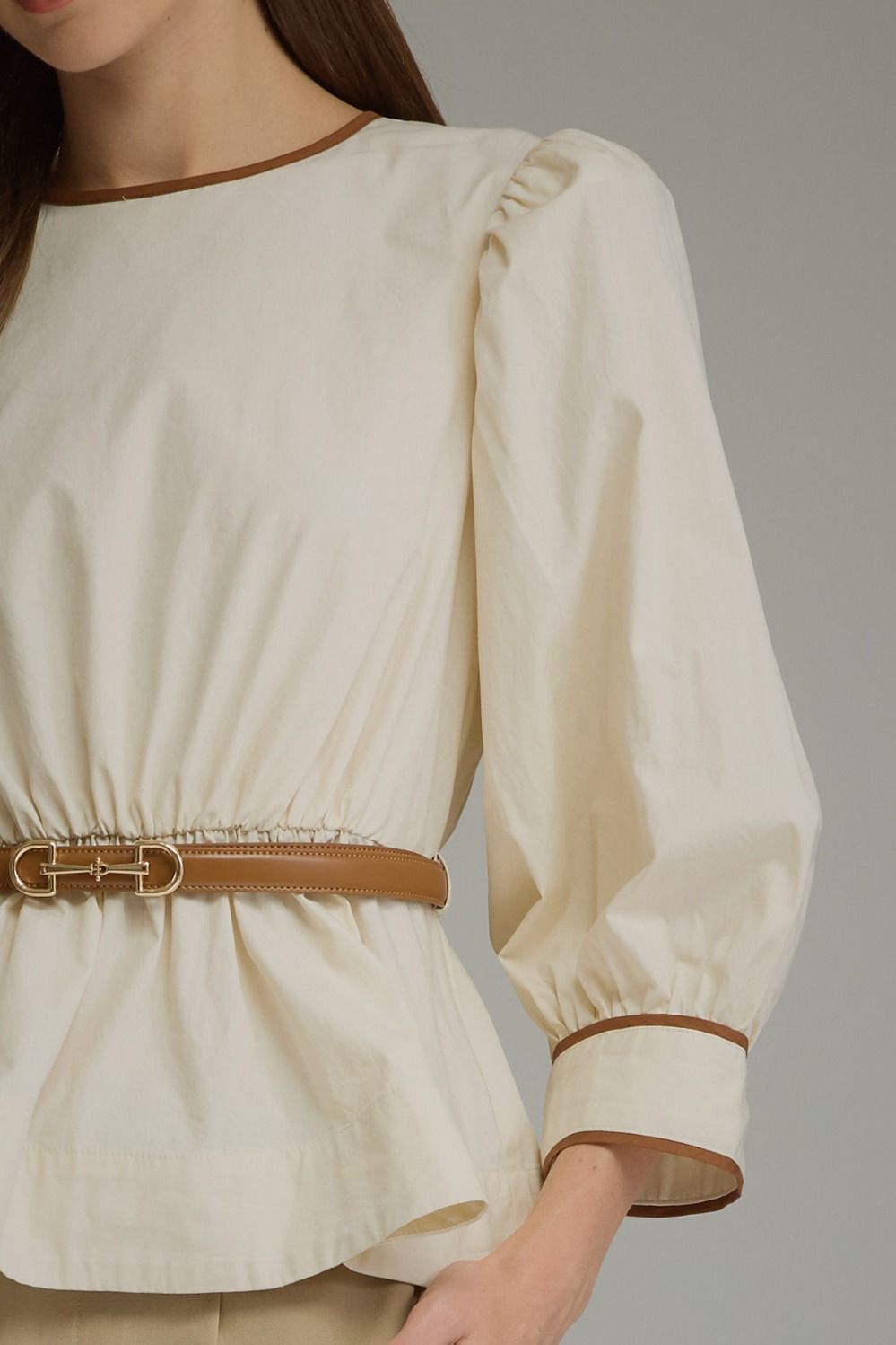 Close-up of ecru top contrast trim and detachable brown belt
