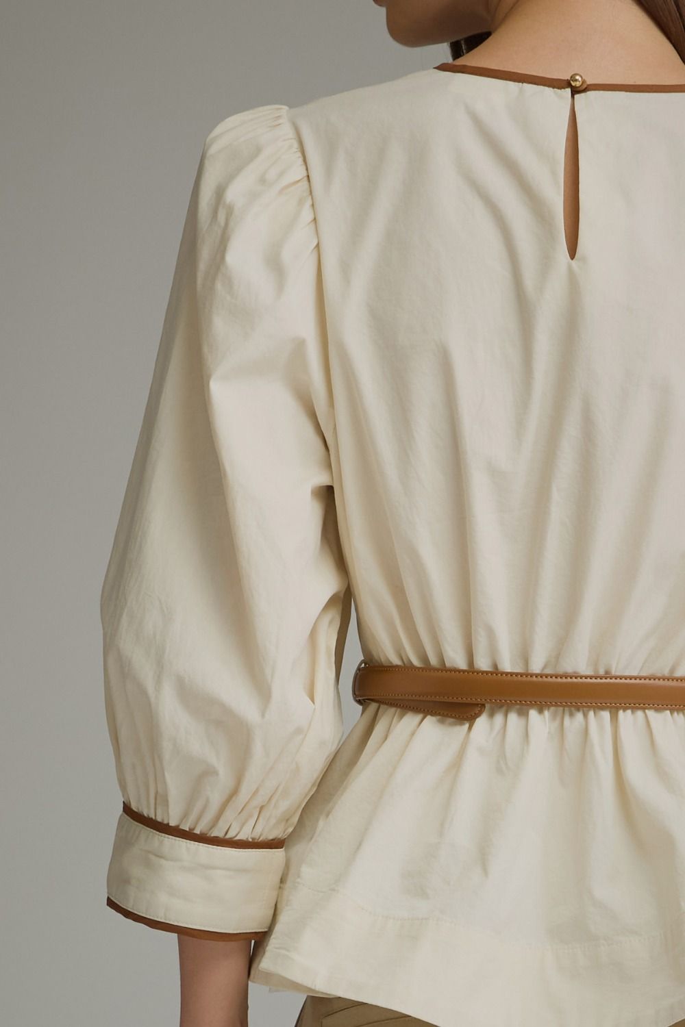 Close-up of ecru puff sleeve top back and sleeve trim detail