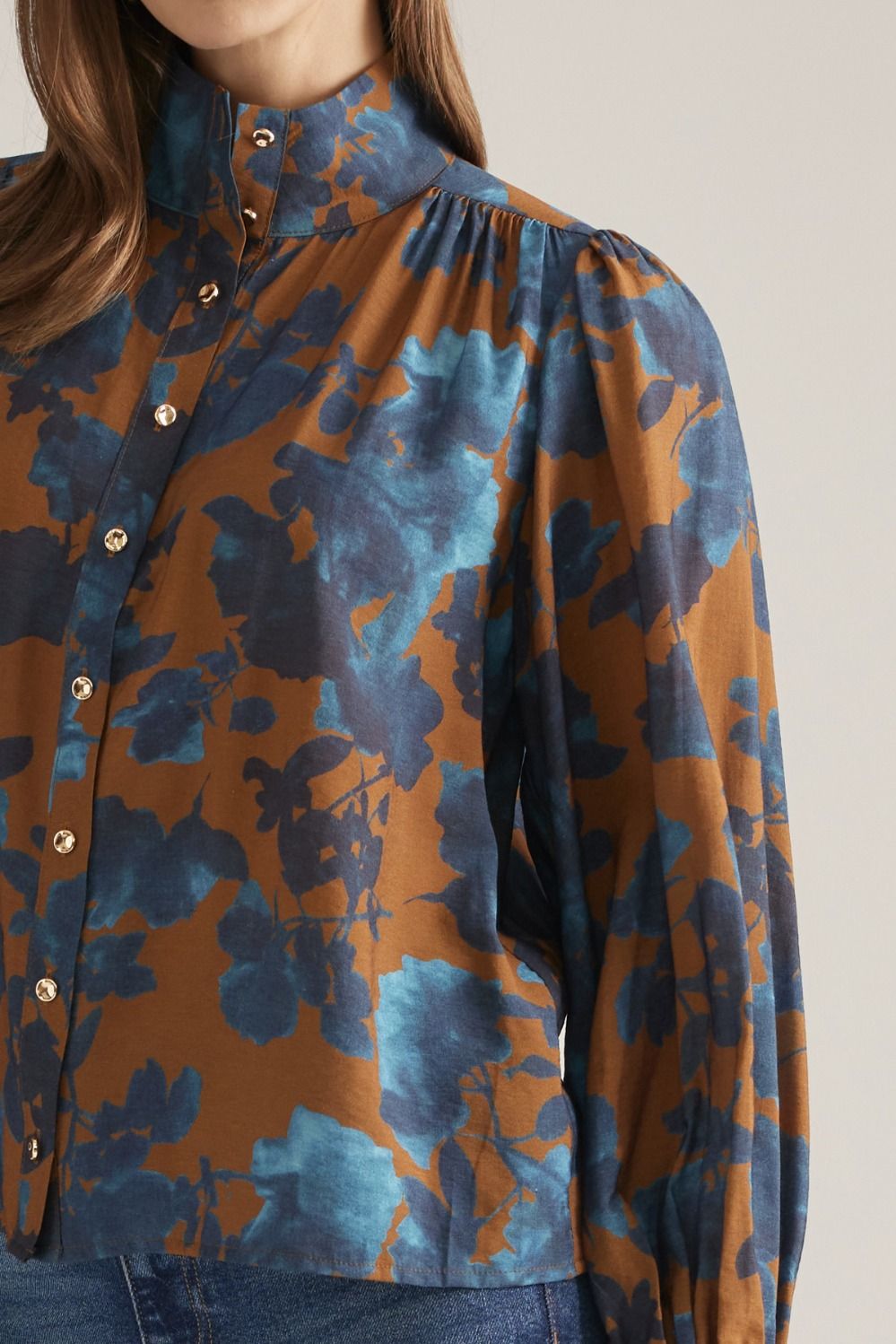 Close-up of camel and teal floral print and stand collar
