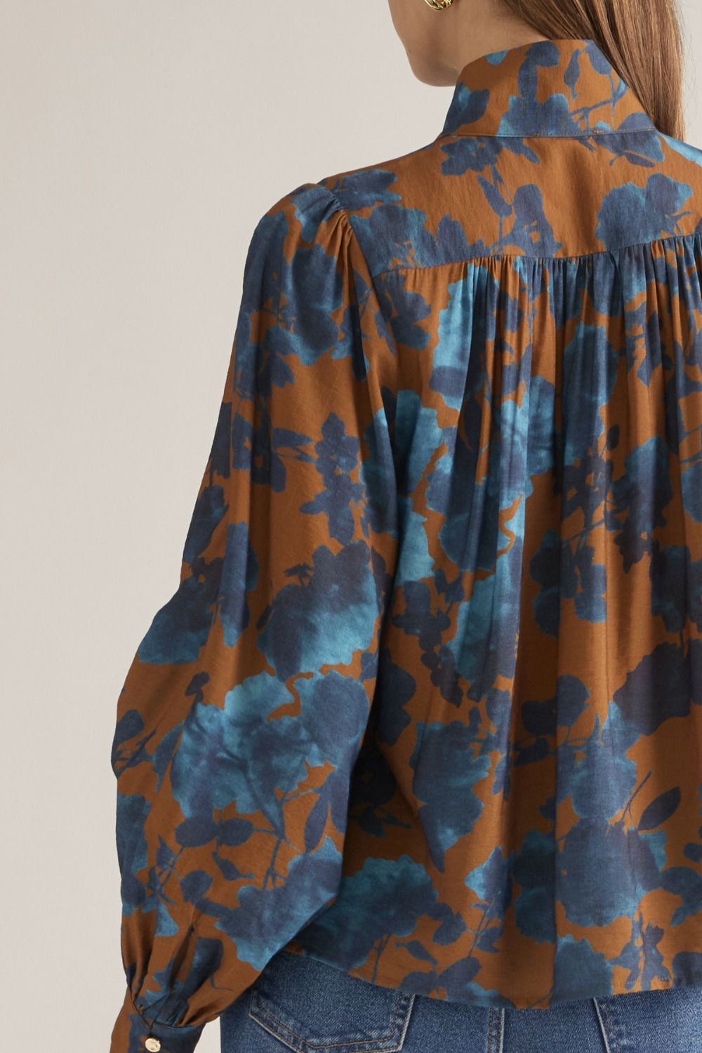 Close-up of gathered back yoke on camel floral blouse
