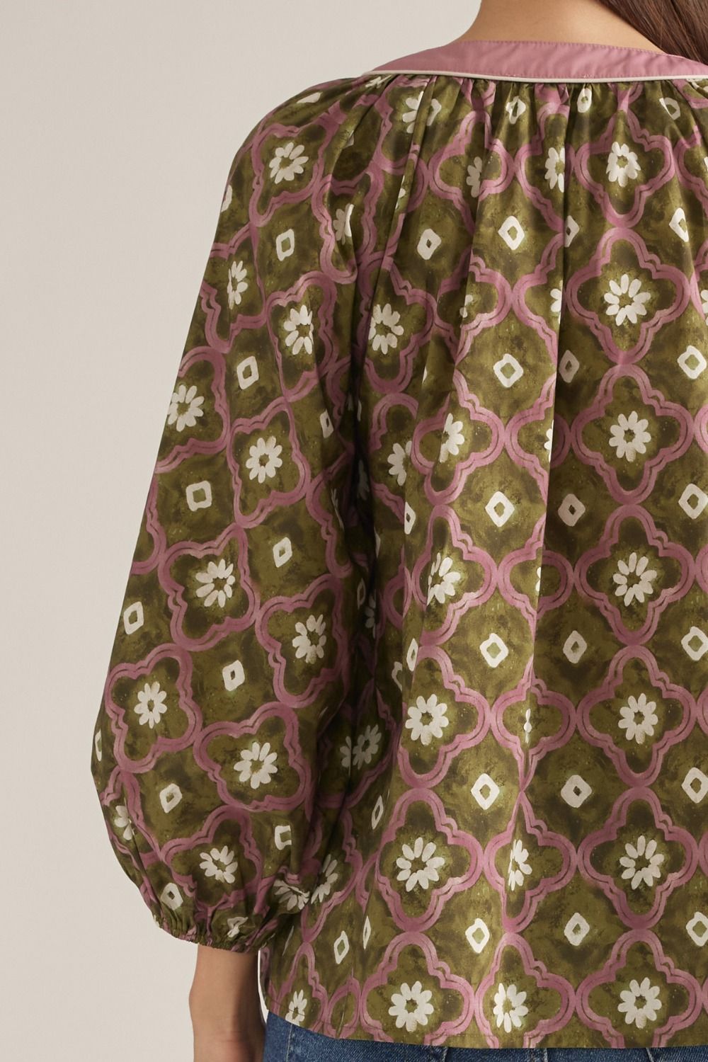 Close-up back detail of olive geo floral puff sleeve top