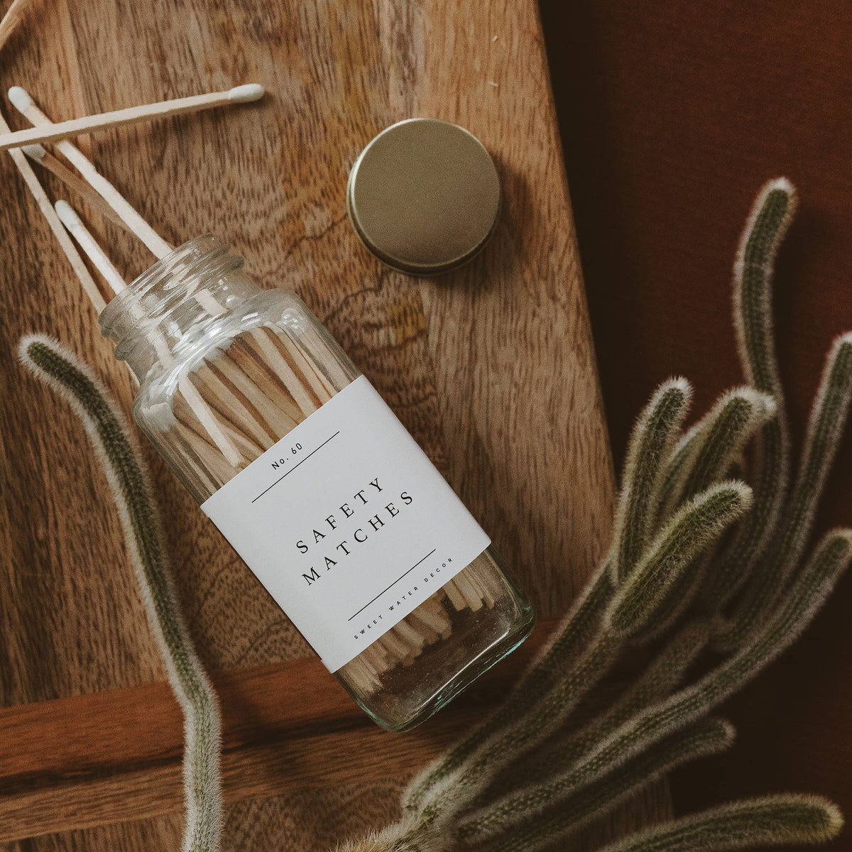 White tip safety matches spilled from the glass jar on a wood tray