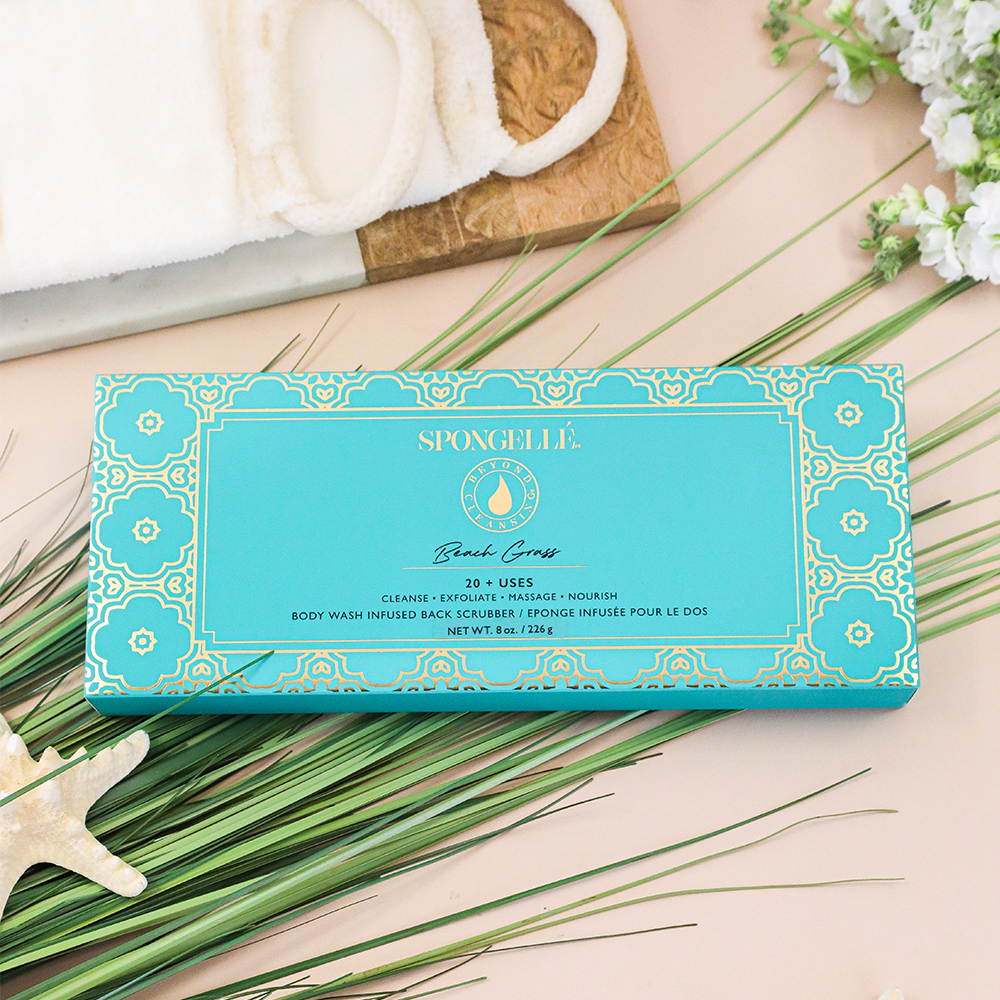 Spongelle product packaging on a wooden surface with greenery