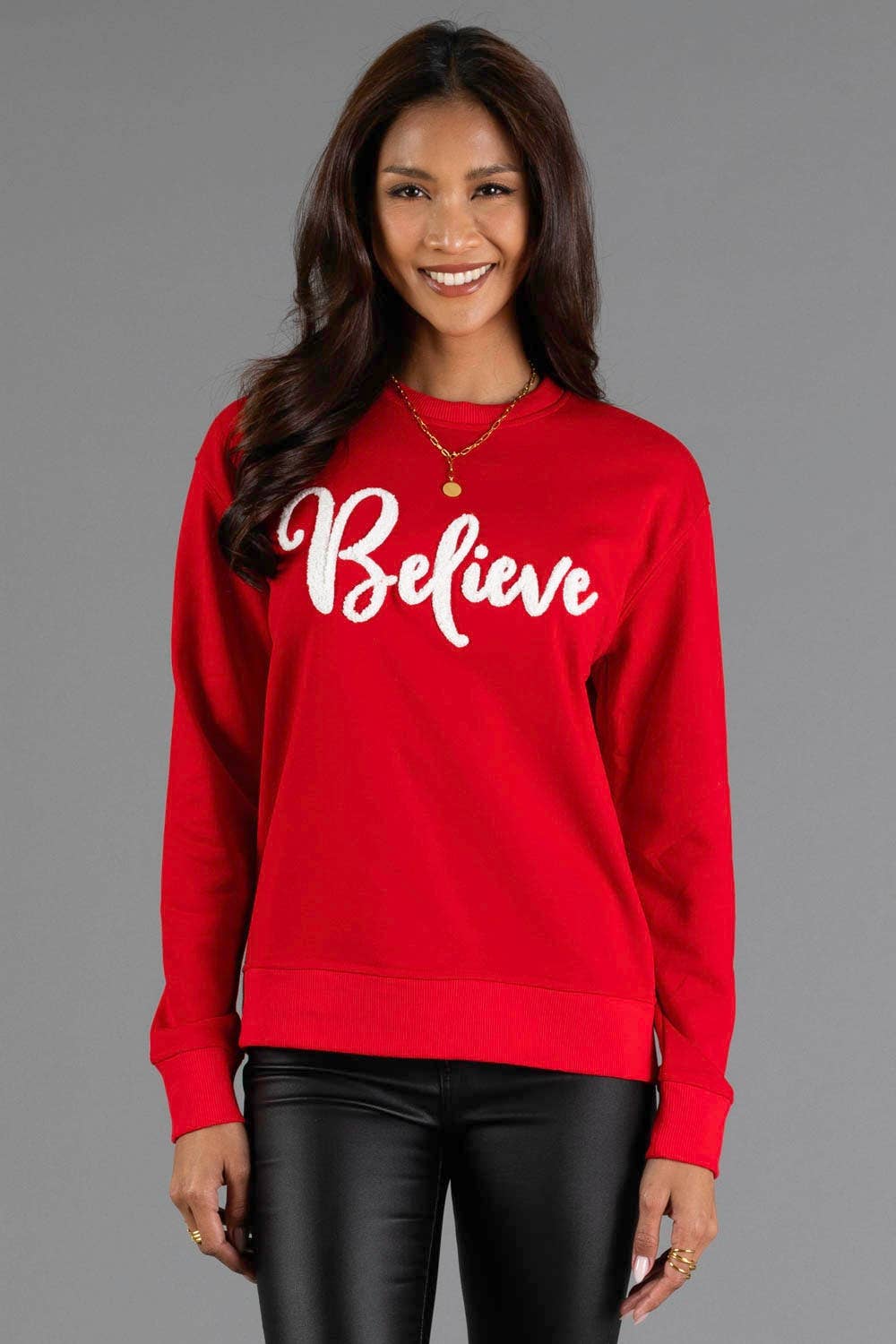 Front view of red crewneck sweatshirt with white Believe script lettering