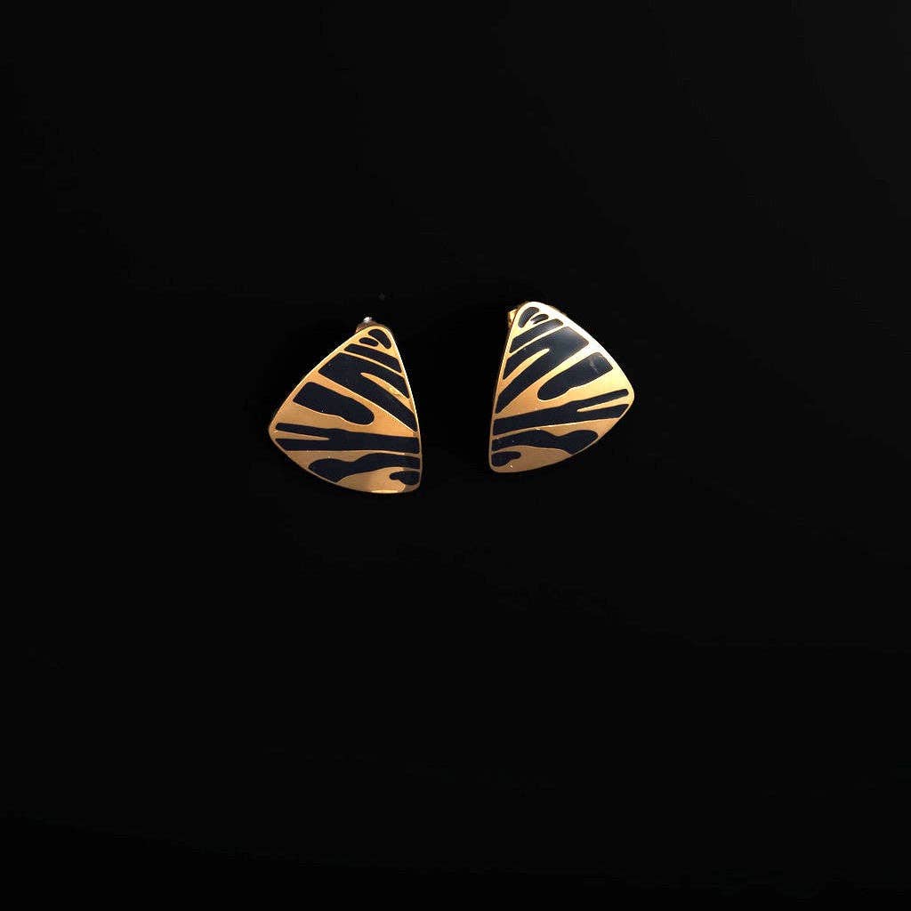 A pair of fan-shaped gold earrings with a black zebra-like stripe pattern, displayed on a solid black background.