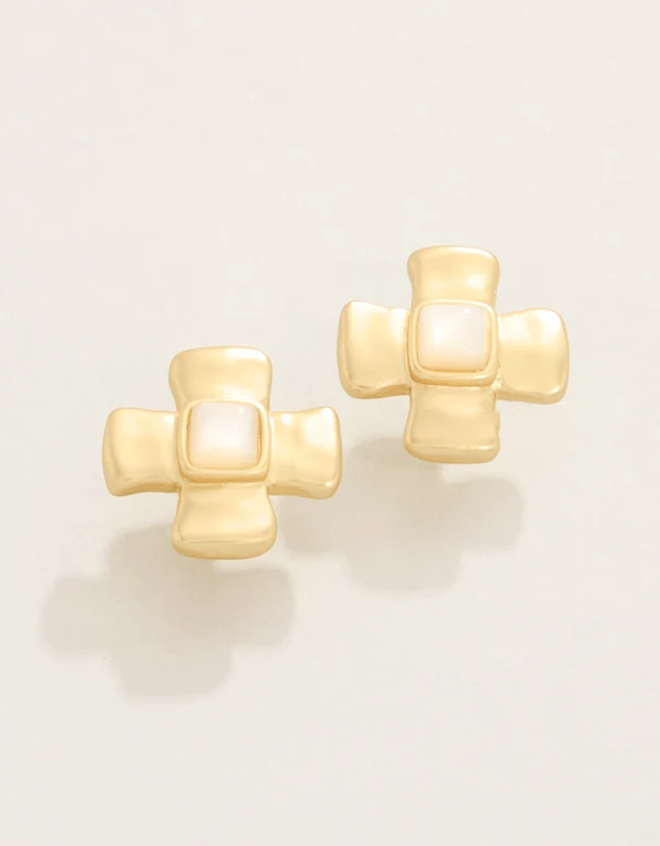 A pair of gold cross-shaped stud earrings with a central square white inlay, displayed on a clean off-white background.