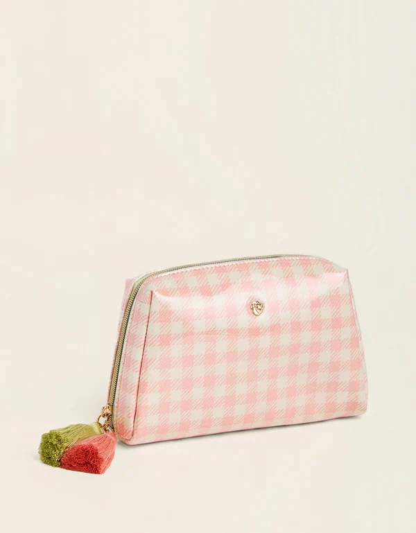 A pink and white gingham cosmetic pouch with a gold zipper and a small rose-shaped tassel charm, set against a plain off-white background.