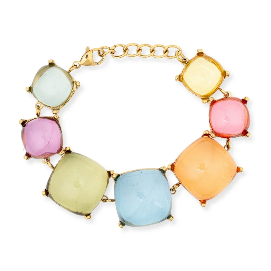 A gold chain bracelet featuring seven large, cushion-cut pastel gemstones in light blue, yellow-green, pink, orange, and pale yellow, set in gold prong settings on a white background.