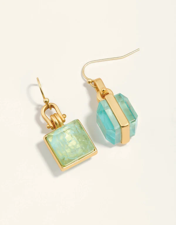 A pair of gold-tone drop earrings featuring faceted light blue-green gemstones in square and rounded bezel settings, shown on a clean off-white background.
