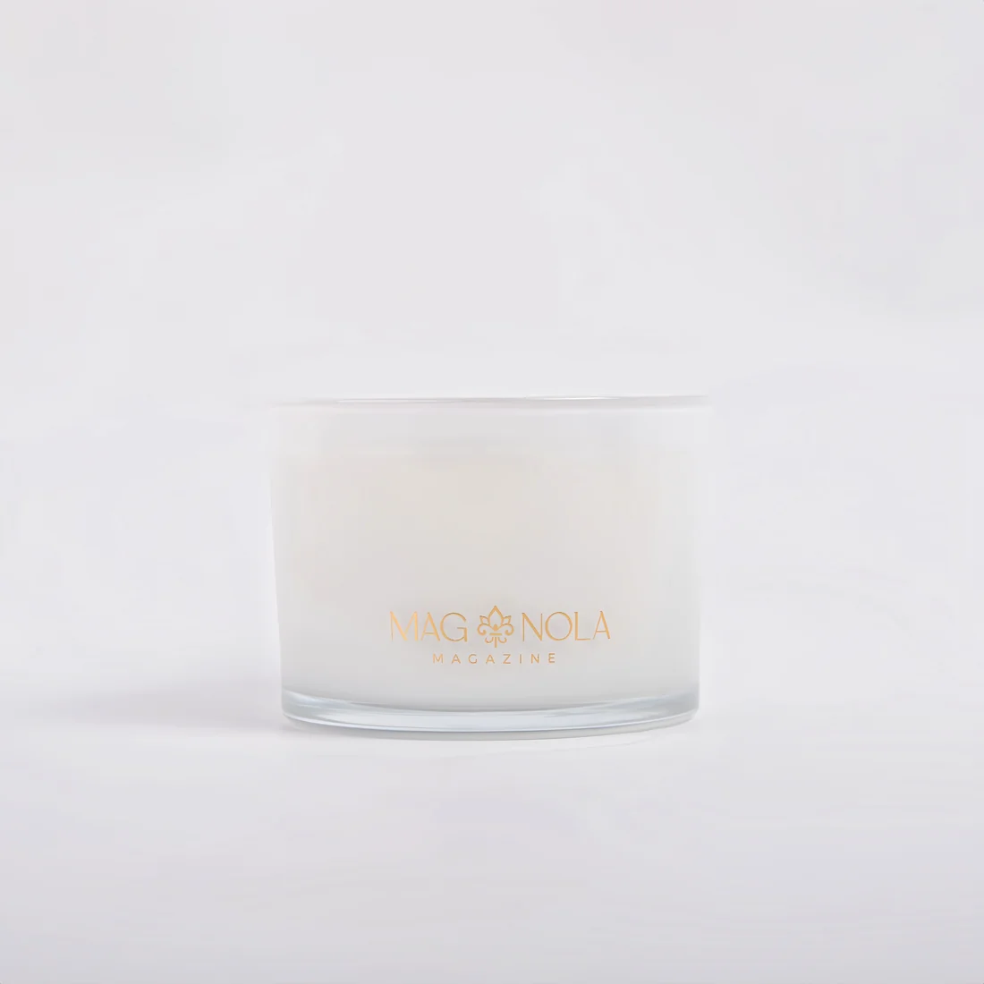 A frosted 14 oz glass jar candle with white wax and gold foil branding reading 'MAGNOLA MAGAZINE', centered on a clean white background.