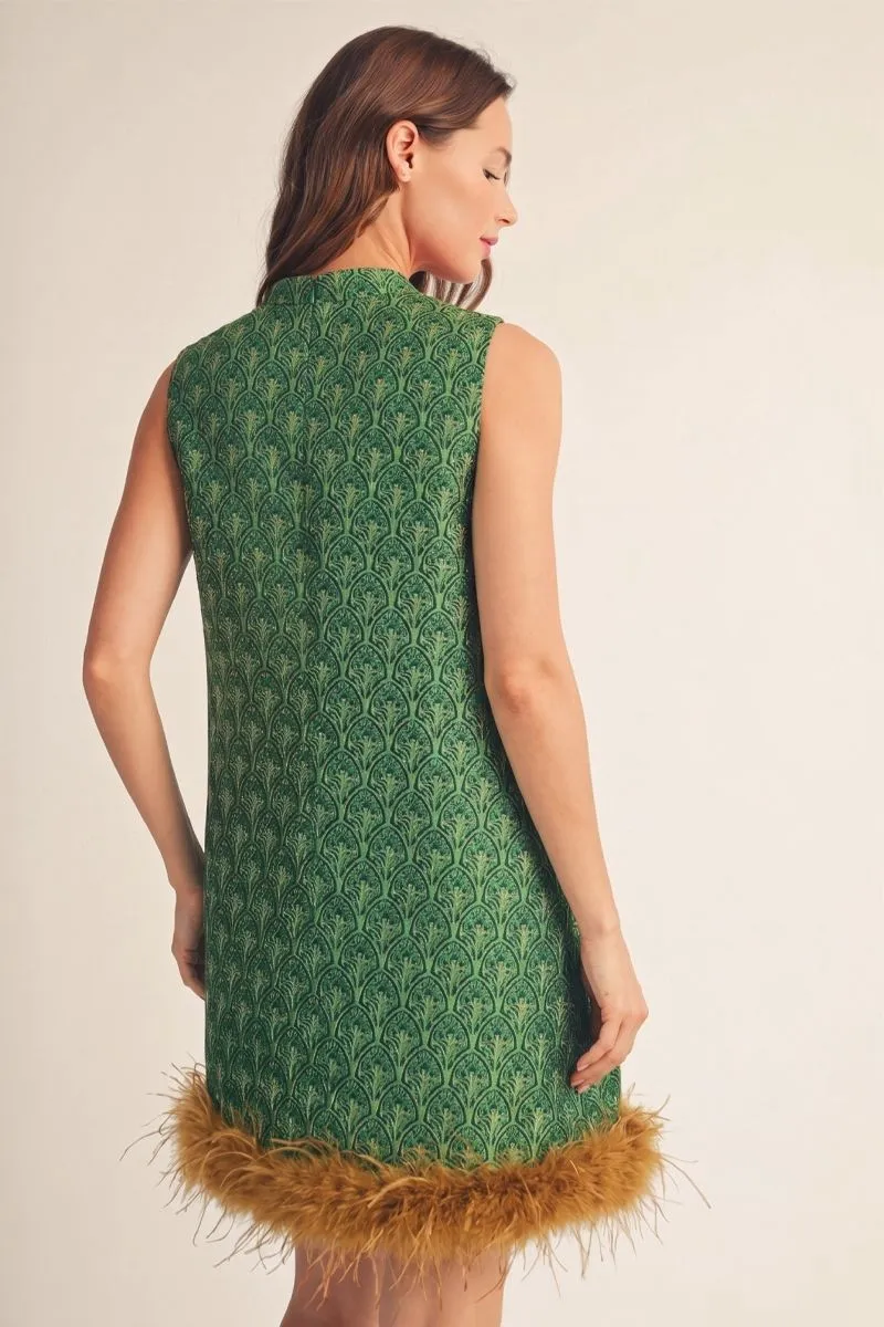 Back view of the green jacquard dress showing the feather-trim hem