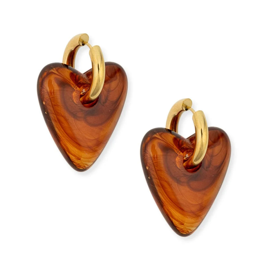 A pair of heart-shaped drop earrings made of amber-colored glass with gold-tone hoops at the top, shown on a plain white background.