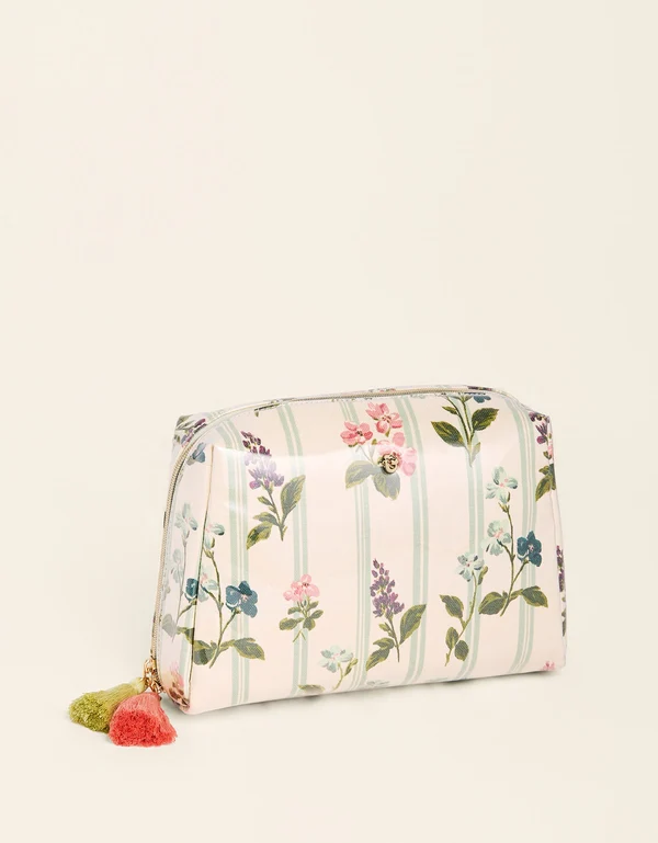 A small zippered cosmetic pouch with a pastel floral and vertical stripe pattern, featuring two decorative tassels on the zipper pull, set against a plain off-white background.