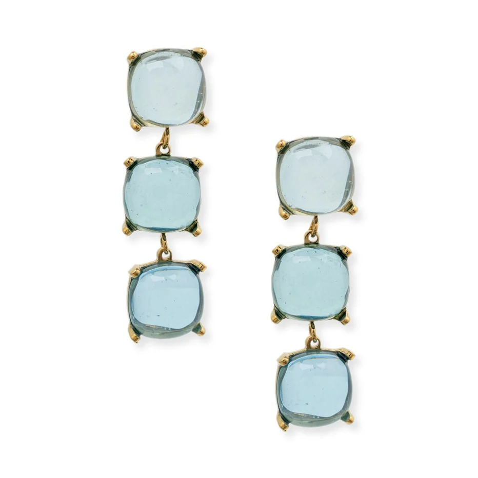 A pair of drop earrings featuring three stacked, cushion-cut light blue gemstones in gold prong settings, shown against a plain white background.