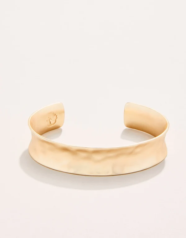 Gold bracelet on a light beige background