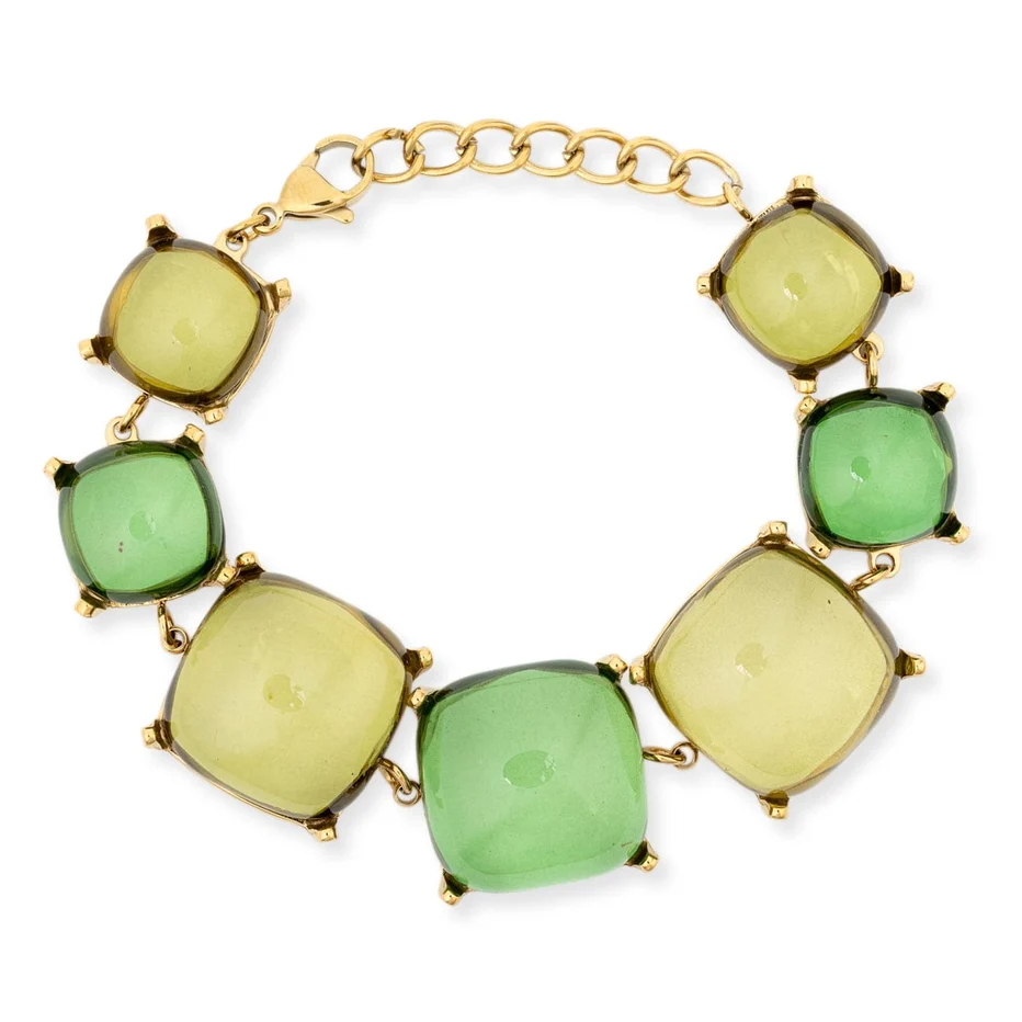 A gold chain bracelet featuring seven cushion-cut green and yellow-green gemstones in gold prong settings, displayed on a clean white background.