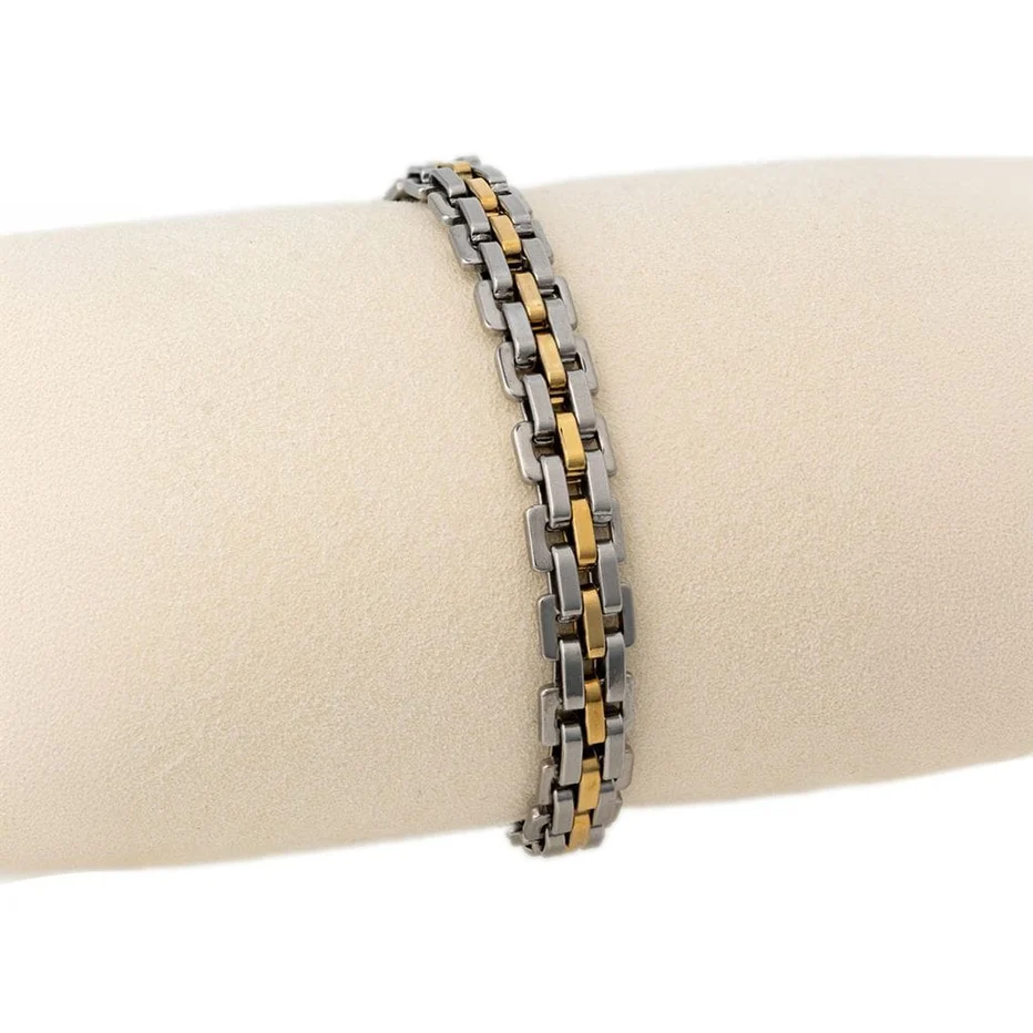 Two-tone metal bracelet on a wrist against a white background