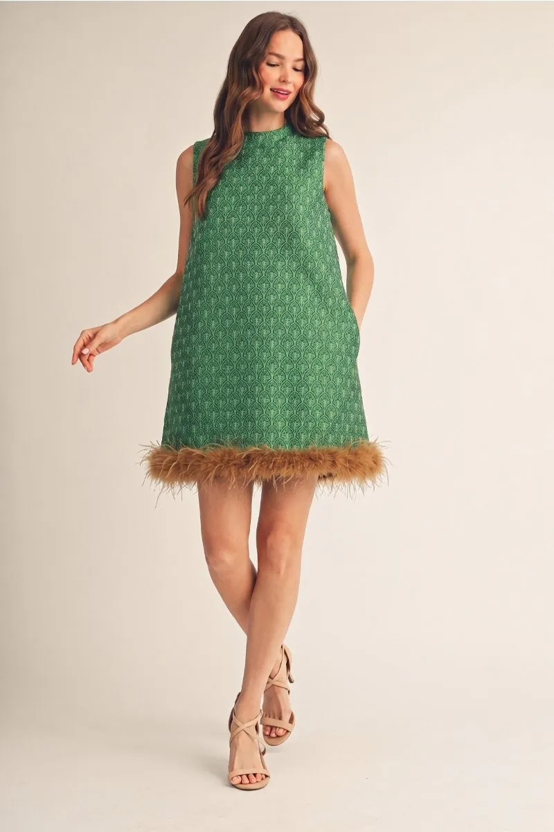 Full-length view of the green jacquard feather-hem dress with a hand in the side pocket