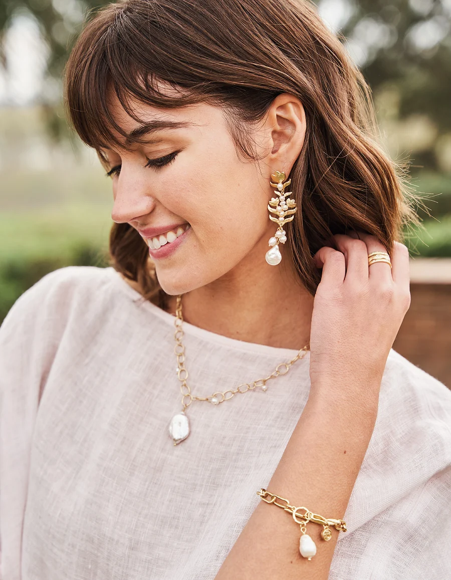 Woman wearing gold earrings and bracelet