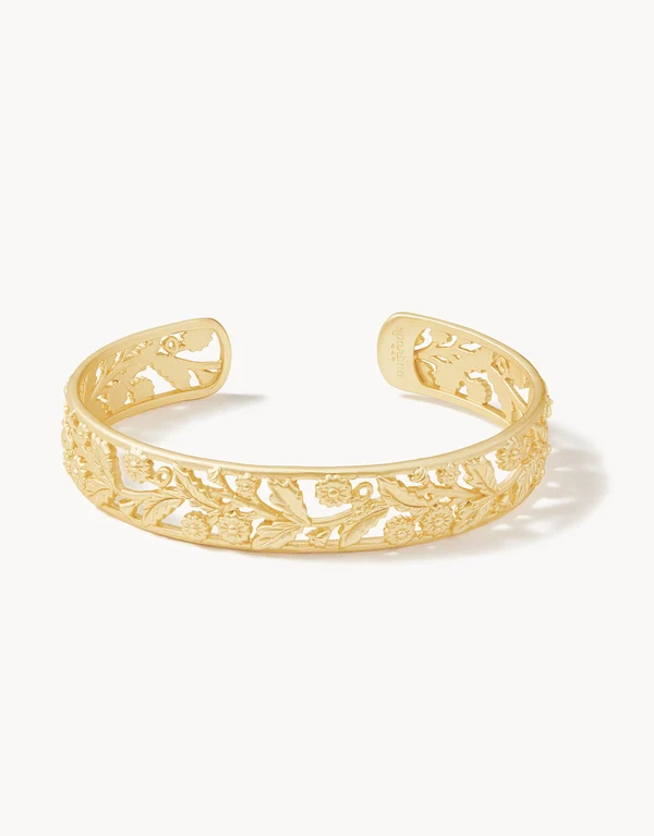 Gold cuff bracelet with floral vine detailing. 