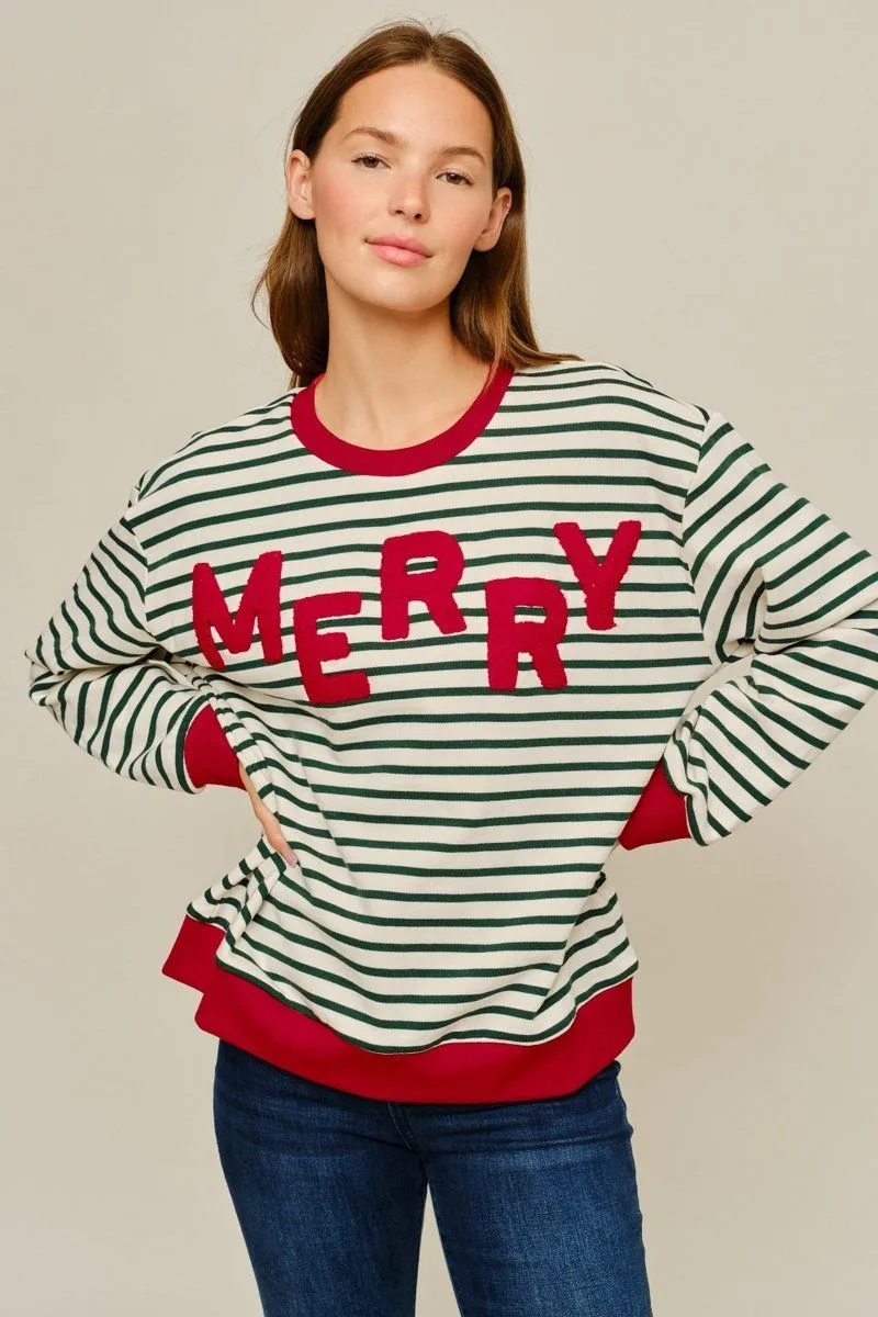 Model with hand on hip wearing the striped MERRY pullover with red ribbed hem and cuffs