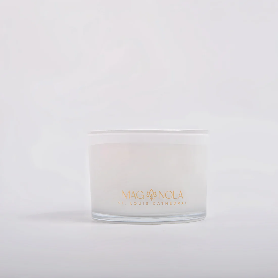 A frosted 14 oz glass jar candle with a white wax fill and gold foil branding that reads 'MAG NOLA' and 'ST. LOUIS CATHEDRAL' on a clean white background.
