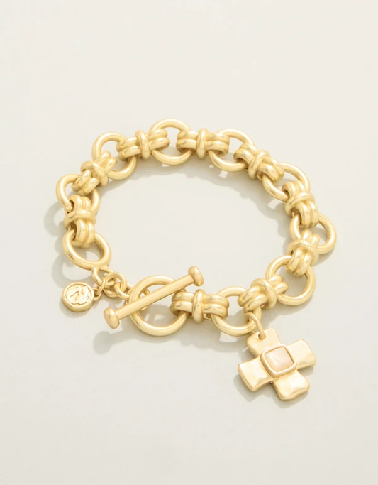 Gold chain bracelet with charms on a light beige background