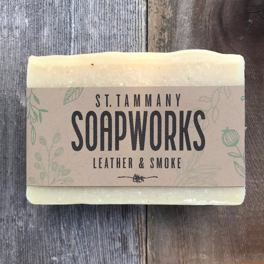 Leather and Smoke Soap bar by St. Tammany Soapworks with kraft label on wood