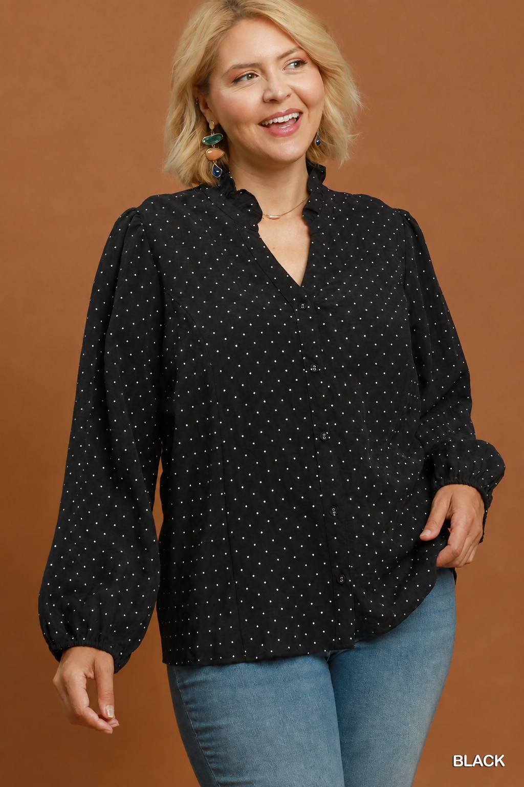 Model wearing a black Swiss dot ruffle collar button-front top with jeans