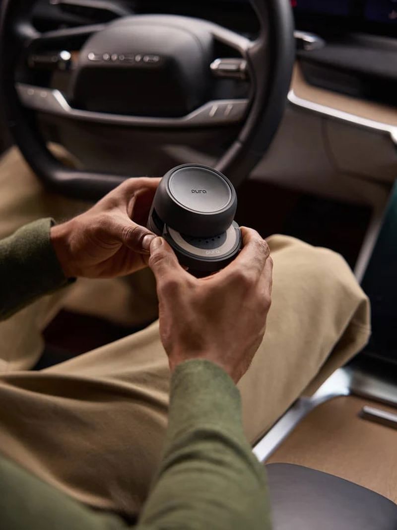Person holding a black Pura car fragrance diffuser
